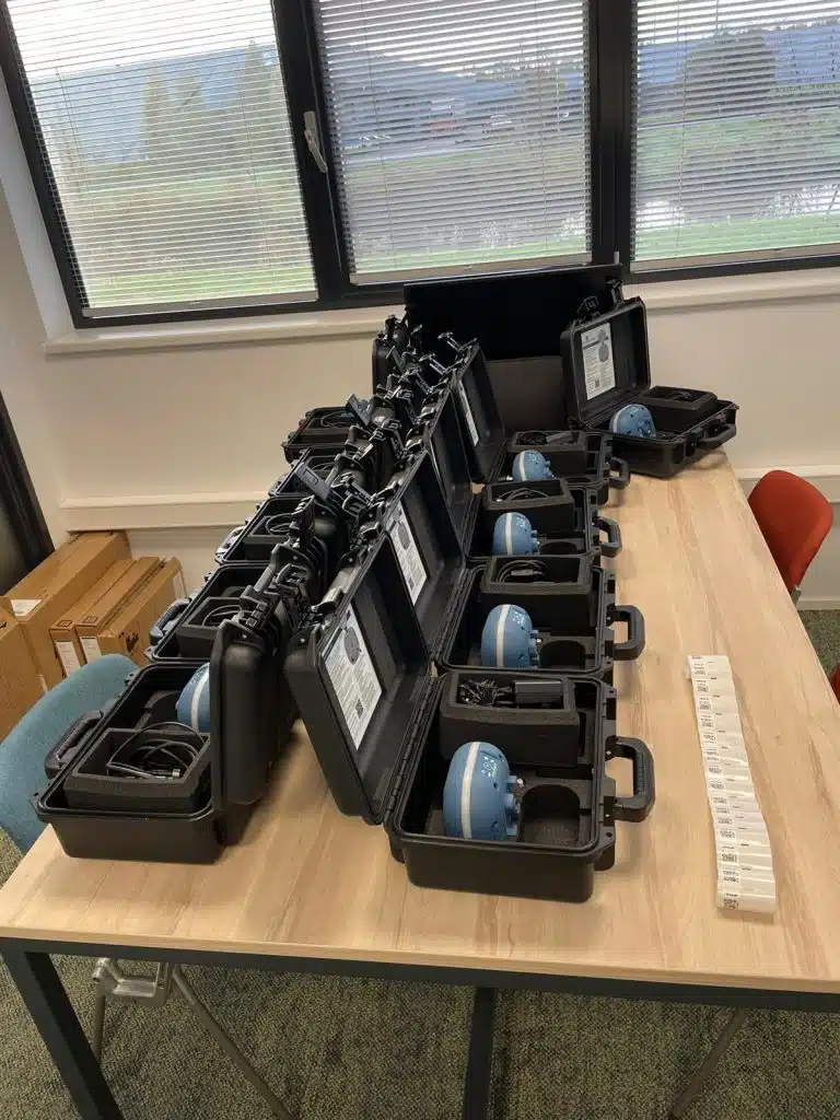 Black carry cases with GNSS receivers laid out on a table in the Verkley office