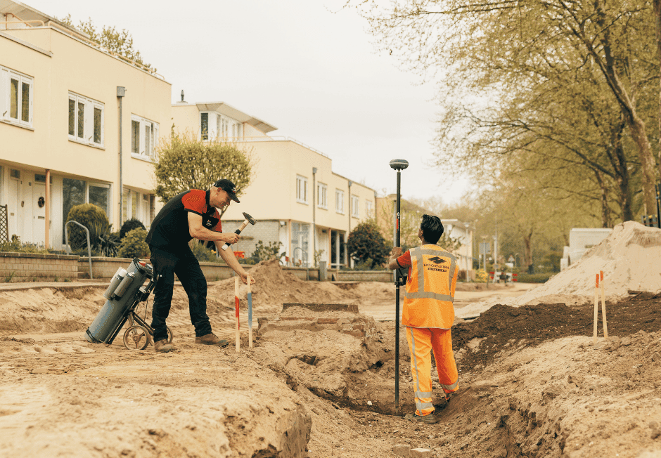 Twee medewerkers zetten punten uit met een UNI-GR2 GNSS-ontvanger in een woonstraat