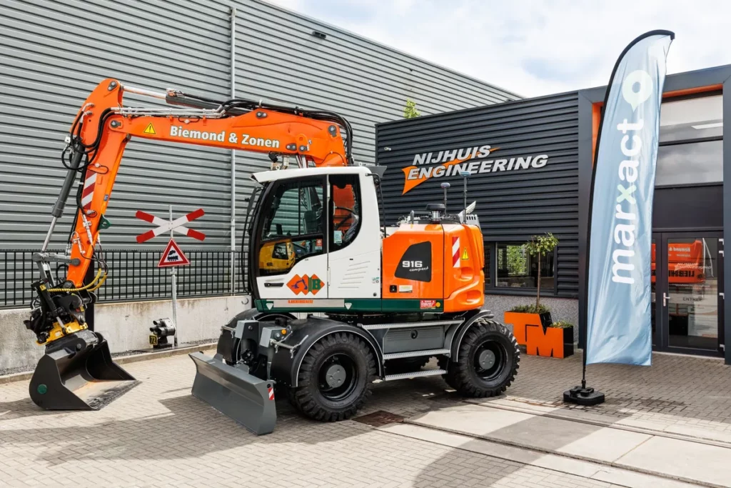 Ein Liebherr 916 Compact mit Tiltrotator und UNI-GR2-Empfängern vor dem Gebäude von Nijhuis Engineering